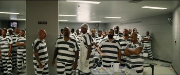 Movie still from “Logan Lucky” (2017), directed by Steven Soderbergh – A group of men in prison uniforms standing in a room; Wide shot, High angle