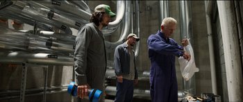 Movie still from “Logan Lucky” (2017), directed by Steven Soderbergh – A group of men standing next to each other in front of pipes; Medium shot, Low angle
