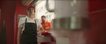 Movie still from “Logan Lucky” (2017), directed by Steven Soderbergh – A woman in an apron standing in front of a counter; Medium shot, Low angle