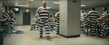 Movie still from “Logan Lucky” (2017), directed by Steven Soderbergh – A group of men in prison uniforms are walking; Wide shot, Low angle
