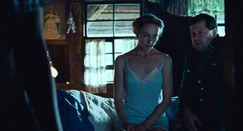 Movie still from “Lore” (2012), directed by Cate Shortland – A woman sitting on top of a couch in a room; Medium shot, Low angle