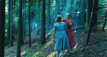 Movie still from “Lore” (2012), directed by Cate Shortland – Two women in a forest with trees in the background; Wide shot, Low angle