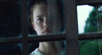 Movie still from “Lore” (2012), directed by Cate Shortland – A young girl looking out a window in a cage; Close Up shot, Low angle