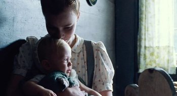 Movie still from “Lore” (2012), directed by Cate Shortland – A woman holding a baby in her arms; Close Up shot, Over the shoulder angle