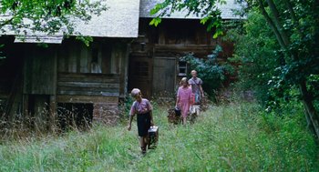 Movie still from “Lore” (2012), directed by Cate Shortland – A group of people walking through a field; Wide shot, Low angle