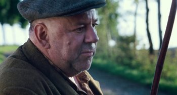 Movie still from “Lore” (2012), directed by Cate Shortland – An older man wearing a hat and a brown jacket; Close Up shot, Over the shoulder angle