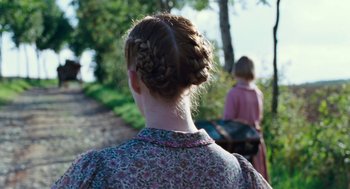 Movie still from “Lore” (2012), directed by Cate Shortland – A woman in a floral dress with two plaits in her hair; Close Up shot, Over the shoulder angle