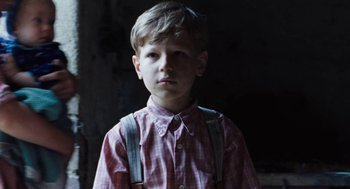 Movie still from “Lore” (2012), directed by Cate Shortland – A young boy wearing a plaid shirt and suspenders; Close Up shot, Low angle