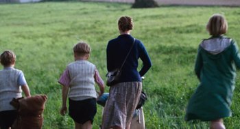 Movie still from “Lore” (2012), directed by Cate Shortland – A woman and a child are walking through a field; Medium shot, Over the shoulder angle