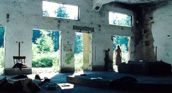 Movie still from “Lore” (2012), directed by Cate Shortland – A woman standing inside of an abandoned building; Wide shot, Low angle