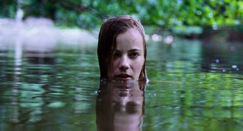 Movie still from “Lore” (2012), directed by Cate Shortland – A girl in a body of water with trees in the background; Close Up shot, Low angle