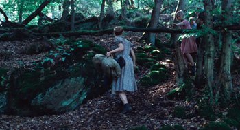 Movie still from “Lore” (2012), directed by Cate Shortland – A woman in a blue dress is holding onto a teddy bear; Wide shot, High angle