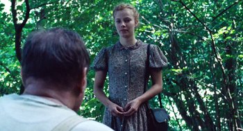 Movie still from “Lore” (2012), directed by Cate Shortland – A woman in a dress standing in front of a man; Medium shot, Over the shoulder angle
