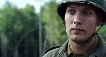 Movie still from “Lore” (2012), directed by Cate Shortland – A man in a military uniform with a helmet on his head; Close Up shot, Over the shoulder angle