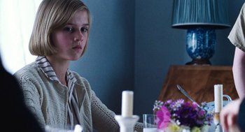 Movie still from “Lore” (2012), directed by Cate Shortland – A woman sitting at a dinner table with a candle; Medium shot, Over the shoulder angle