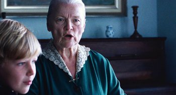 Movie still from “Lore” (2012), directed by Cate Shortland – An older woman in a green shirt is looking at the camera; Close Up shot, Low angle
