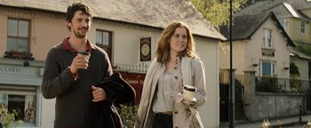 Movie still from “Leap Year” (2010), directed by Anand Tucker – A woman holding a cup of coffee while standing next to a man; Medium shot, Over the shoulder angle