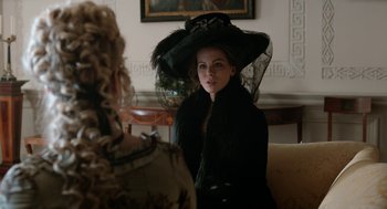 Movie still from “Love & Friendship” (2016), directed by Whit Stillman – A woman in a black hat and a black coat; Close Up shot, Over the shoulder angle
