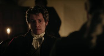Movie still from “Love & Friendship” (2016), directed by Whit Stillman – A young man in a suit and a white neck tie; Close Up shot, Over the shoulder angle