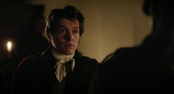Movie still from “Love & Friendship” (2016), directed by Whit Stillman – A man in a suit and tie looking at the camera; Close Up shot, Over the shoulder angle