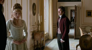Movie still from “Love & Friendship” (2016), directed by Whit Stillman – A man and a woman standing in front of a wall; Medium shot, Over the shoulder angle