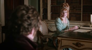 Movie still from “Love & Friendship” (2016), directed by Whit Stillman – A woman sitting at a table in front of another woman; Medium shot, Over the shoulder angle