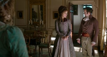 Movie still from “Love & Friendship” (2016), directed by Whit Stillman – A man and woman standing in front of a dining room table; Medium shot, Over the shoulder angle