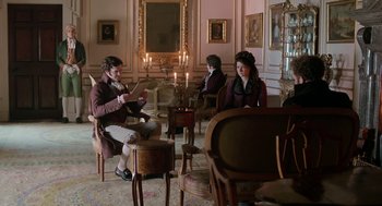 Movie still from “Love & Friendship” (2016), directed by Whit Stillman – A group of people sitting in a room with candles; Wide shot, High angle