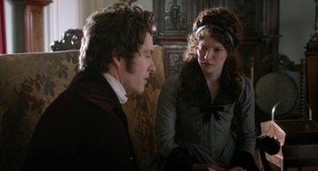 Movie still from “Love & Friendship” (2016), directed by Whit Stillman – A man and a woman sitting on a chair; Medium shot, Over the shoulder angle
