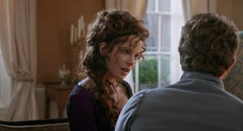 Movie still from “Love & Friendship” (2016), directed by Whit Stillman – A woman with long curly brown hair wearing a purple top; Close Up shot, Over the shoulder angle