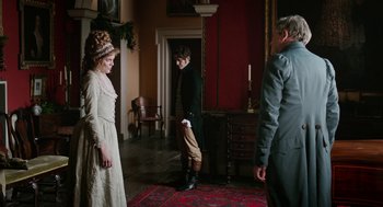 Movie still from “Love & Friendship” (2016), directed by Whit Stillman – A group of people standing in a room; Wide shot, Over the shoulder angle