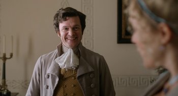 Movie still from “Love & Friendship” (2016), directed by Whit Stillman – A man wearing a suit and tie smiling for the camera; Close Up shot, Over the shoulder angle