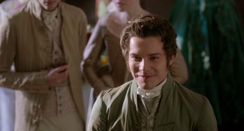 Movie still from “Love & Friendship” (2016), directed by Whit Stillman – A young man in a green jacket smiling for the camera; Close Up shot, Over the shoulder angle