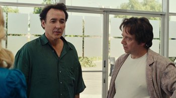 Movie still from “Love & Mercy” (2014), directed by Bill Pohlad – Two men standing next to each other in front of a window; Medium shot, Over the shoulder angle