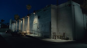 Movie still from “Love & Mercy” (2014), directed by Bill Pohlad – A car parked on the side of the road next to a building; Extreme Wide shot, Low angle