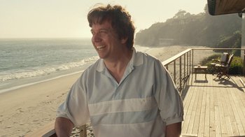 Movie still from “Love & Mercy” (2014), directed by Bill Pohlad – A man standing next to the ocean on the beach; Medium shot, Over the shoulder angle