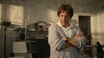 Movie still from “Love & Mercy” (2014), directed by Bill Pohlad – A man standing with his arms crossed in a room; Medium shot, Over the shoulder angle