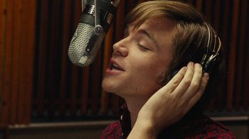 Movie still from “Love & Mercy” (2014), directed by Bill Pohlad – A man with his eyes closed in front of a microphone; Close Up shot, Low angle