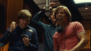 Movie still from “Love & Mercy” (2014), directed by Bill Pohlad – Three young men in a recording studio one of them is holding a microphone; Medium shot, Low angle