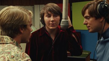 Movie still from “Love & Mercy” (2014), directed by Bill Pohlad – Three young men are talking in a recording studio; Medium shot, Over the shoulder angle