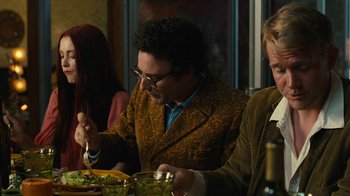 Movie still from “Love & Mercy” (2014), directed by Bill Pohlad – A group of people sitting at a table eating food; Medium shot, Over the shoulder angle