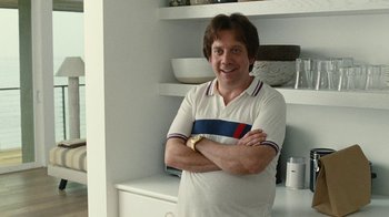 Movie still from “Love & Mercy” (2014), directed by Bill Pohlad – A man standing with his arms crossed in front of a shelf; Medium shot, Over the shoulder angle