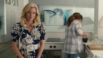 Movie still from “Love & Mercy” (2014), directed by Bill Pohlad – A woman in a blue and white dress standing in a kitchen; Medium shot, Over the shoulder angle