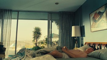 Movie still from “Love & Mercy” (2014), directed by Bill Pohlad – A man laying in bed next to a large window; Medium shot, High angle