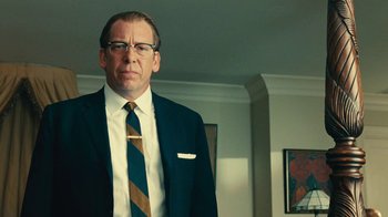 Movie still from “Love & Mercy” (2014), directed by Bill Pohlad – A man in a suit and tie standing in front of a mirror; Medium shot, Low angle