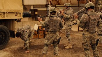 Movie still from “Machete Kills” (2013), directed by Robert Rodriguez – A group of men in military fatigues standing in the dirt; Wide shot, Over the shoulder angle