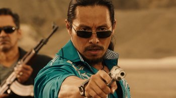 Movie still from “Machete Kills” (2013), directed by Robert Rodriguez – A man in a blue shirt holding a gun in his hand; Close Up shot, Over the shoulder angle