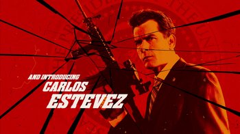 Movie still from “Machete Kills” (2013), directed by Robert Rodriguez – A man holding a gun in front of a red background; Medium shot, Low angle