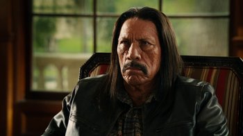 Movie still from “Machete Kills” (2013), directed by Robert Rodriguez – An older man with long hair and a mustache; Close Up shot, Over the shoulder angle