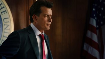 Movie still from “Machete Kills” (2013), directed by Robert Rodriguez – A person wearing a suit and tie; Close Up shot, Over the shoulder angle